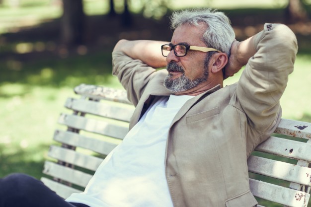 pensive-mature-man-sitting-bench-urban-park_1139-1109